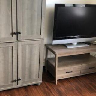 A living room setup featuring a wooden cabinet and a TV on a stand.