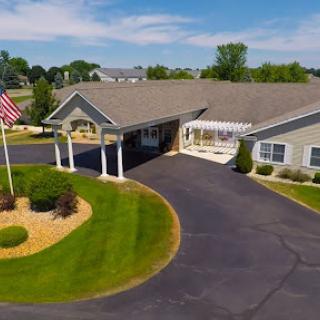 A well-maintained residential building with a manicured lawn and an American flag.