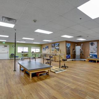 A spacious rehabilitation center equipped with various exercise equipment for physical therapy and wellness.