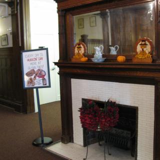 A decorated fireplace display in a museum setting, featuring artifacts and informational signage.