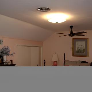 A cozy bedroom with a ceiling fan, bedside lamp, and framed painting on the wall.