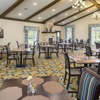 A cozy dining room featuring multiple tables and chairs with elegant interior design elements.