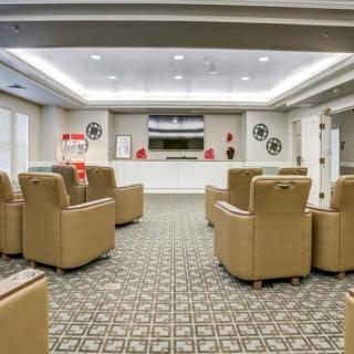 A cozy movie room with recliner seating and a popcorn machine, perfect for an immersive viewing experience.