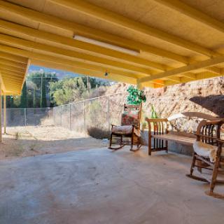 A cozy outdoor porch with wooden furniture, perfect for relaxation and enjoying the view.