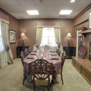 A formal dining room with a long table and elegant decor.