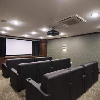 A modern home theater room with comfortable seating and a large screen for movie viewing.