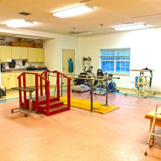 A spacious gym equipped for various fitness and rehabilitation activities.