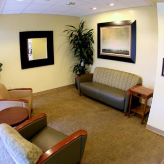 A cozy waiting room with seating and decorative mirrors.