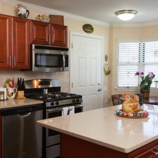 A modern kitchen featuring stainless steel appliances, wooden cabinets, and a spacious countertop.