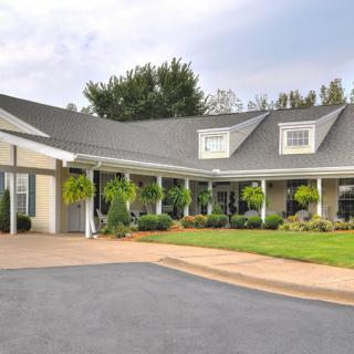 A charming residential house with a driveway and well-maintained garden.