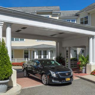 A car parked under the covered entrance of a large building.