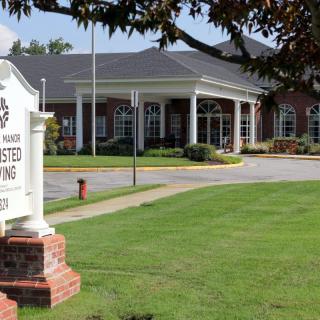 The exterior view of a library with a welcoming entrance and a well-maintained lawn.