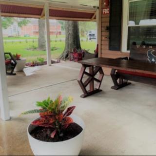 A cozy outdoor patio area featuring a wooden table and decorative plants, perfect for relaxation.