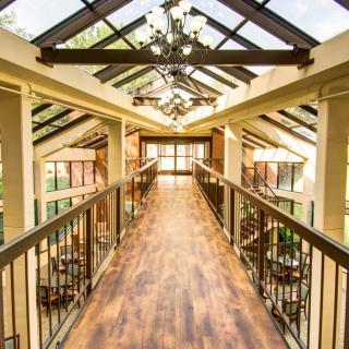 A beautifully designed interior walkway with a glass ceiling and chandeliers, allowing abundant natural light.