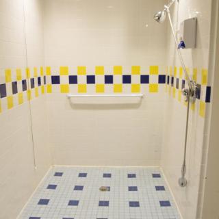 A modern shower space with yellow and blue tiled patterns.