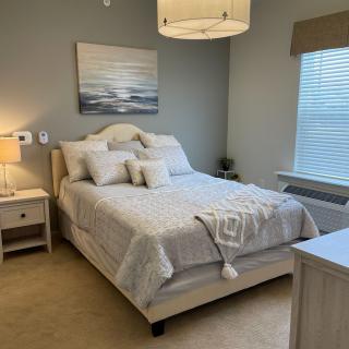 A cozy, well-decorated bedroom with a neatly made bed and soft lighting.