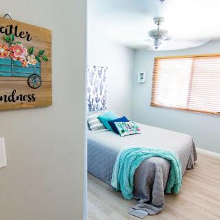 A cozy bedroom with a neatly made bed and decorative wall art.
