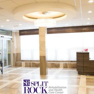 A modern lobby area in a healthcare facility with a reception desk and bright lighting.