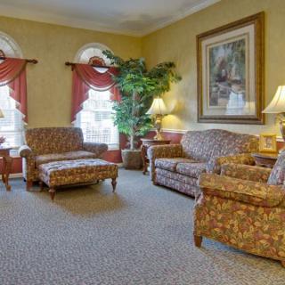 A cozy living room with floral-patterned furniture and warm lighting.