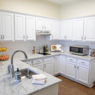 A modern kitchen with white cabinets, featuring a clean and organized countertop.