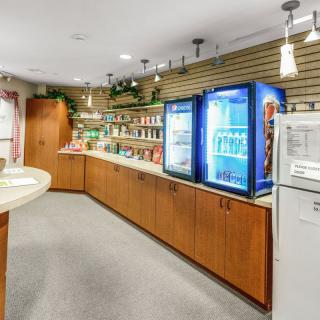 A well-lit grocery store interior with shelves stocked and refrigerators on display.