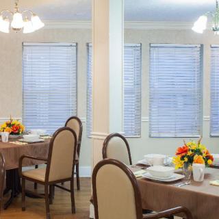 A well-decorated dining room with set tables and floral centerpieces.