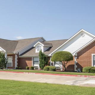 A suburban house with a well-maintained lawn and driveway.
