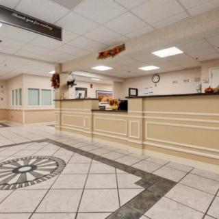 A spacious hotel lobby featuring a decorative floor design and a well-lit reception desk.