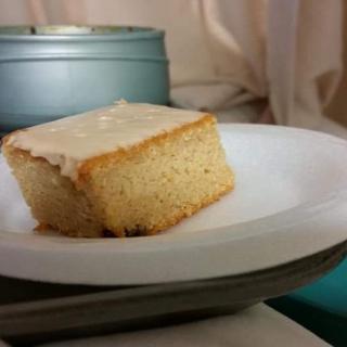 A slice of frosted cake on a white plate.