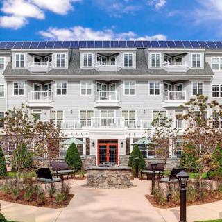 A modern apartment building with well-maintained landscaping and outdoor seating areas.