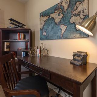 A cozy home office with a vintage typewriter and world map decor.