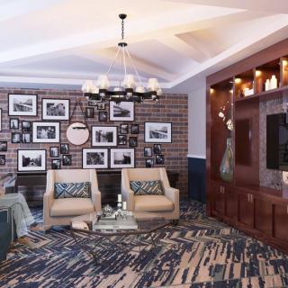 A stylish living room featuring a cozy seating area with two armchairs, surrounded by decorative wall art and a modern chandelier.