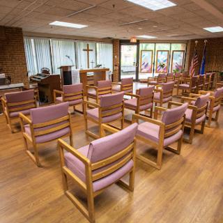 A serene worship space featuring wooden chairs arranged for a gathering.