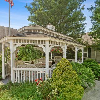 A charming gazebo surrounded by lush greenery and vibrant garden landscaping.