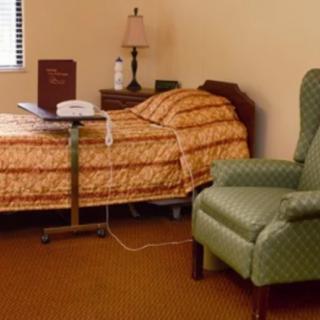 A hospital room with a bed, medical equipment, and a chair.