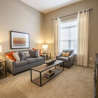 A cozy living room with modern decor, featuring a sofa, armchair, and coffee table.