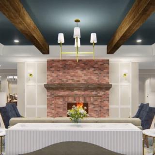 A cozy living room with a stone fireplace, elegant chandeliers, and wooden ceiling beams.