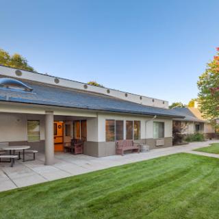 A modern house with a well-maintained garden and clear blue sky.