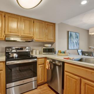 A modern kitchen with wooden cabinets, stainless steel appliances, and a welcoming layout.