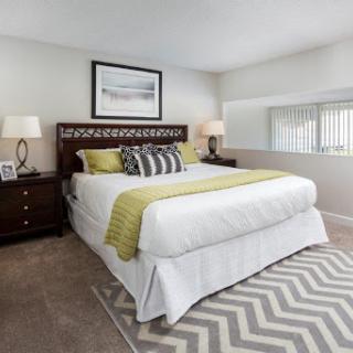 A beautifully designed modern bedroom featuring a comfortable bed, stylish lamps, and soft textiles.