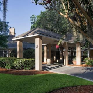 The inviting entrance of a modern building surrounded by lush greenery.