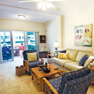 A cozy living room with comfortable seating and a view of the balcony.