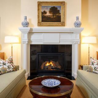 A cozy living room with a fireplace, elegant decor, and comfortable seating.