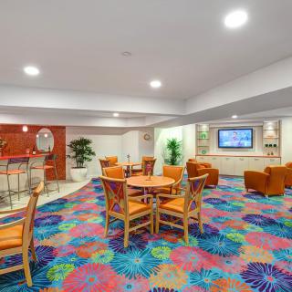 A modern lobby with vibrant, colorful carpeting and comfortable seating.