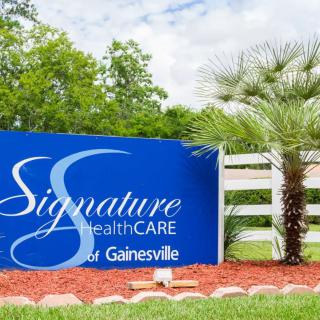 Sign for Signature HealthCARE of Gainesville surrounded by landscaping.