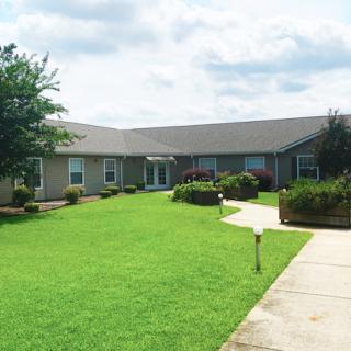 A suburban house with a well-maintained lawn and pathway on a cloudy day.