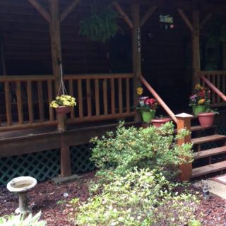 A charming porch with colorful flowers and lush greenery.