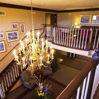A beautifully lit interior space featuring a grand chandelier above a cozy seating area with elegant decor.