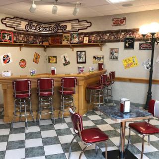 A cozy retro diner setting with classic bar stools and a checkerboard floor.