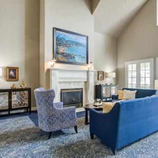 A cozy living room featuring elegant furniture and a central fireplace.